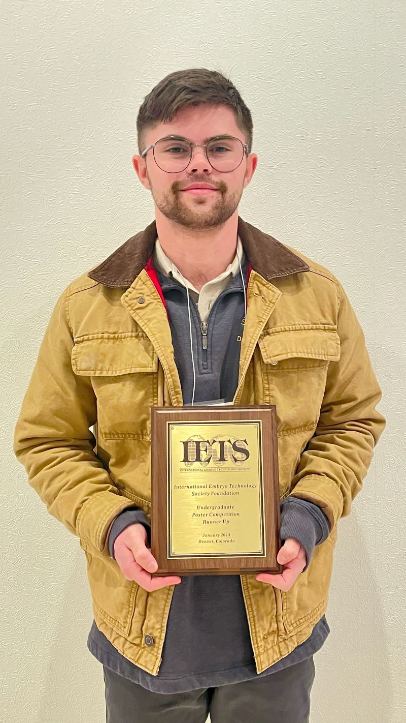 Ashton Dalton standing with his research award