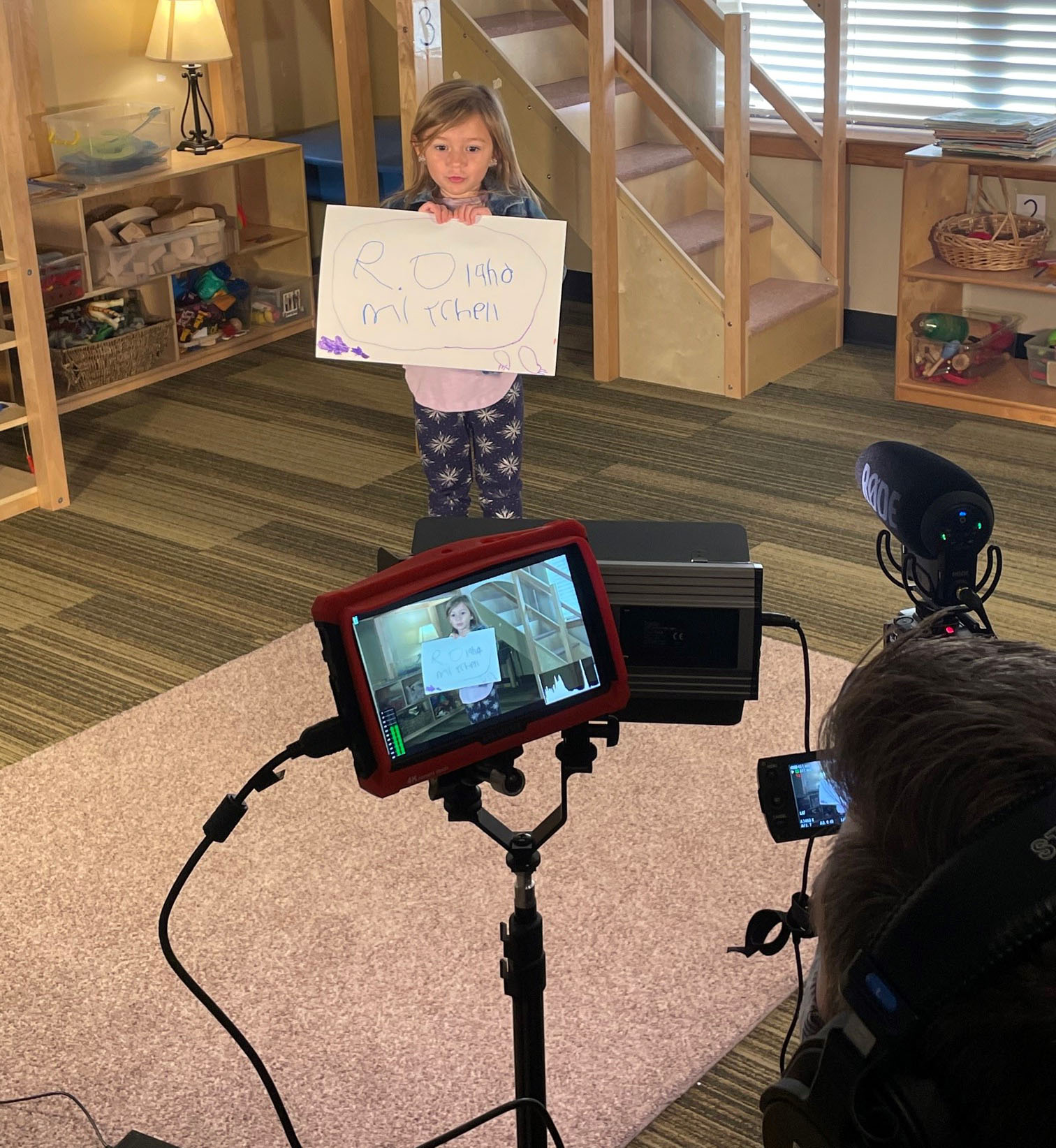 white female child being filmed by video camera