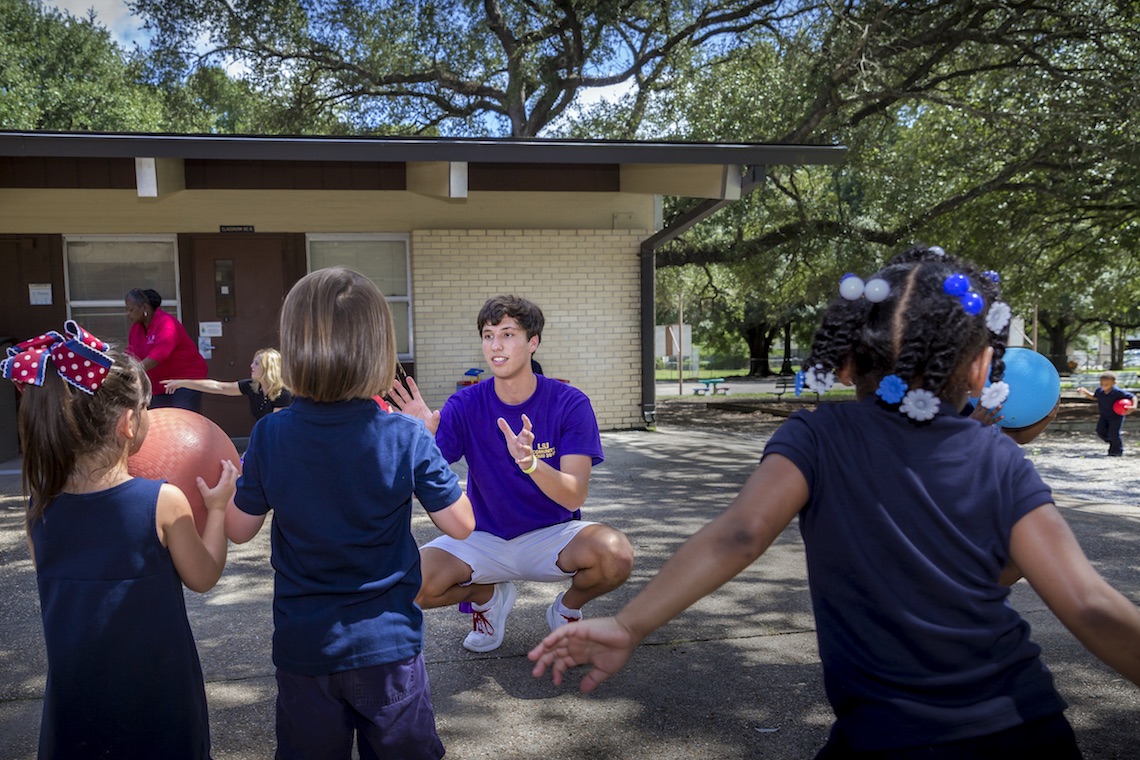 Student helping children.