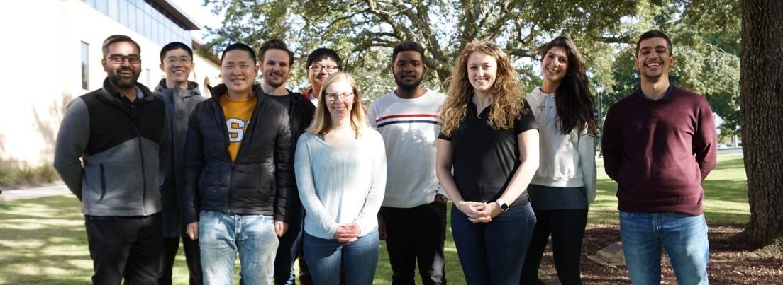 Group of sutdents standing outside under a tree