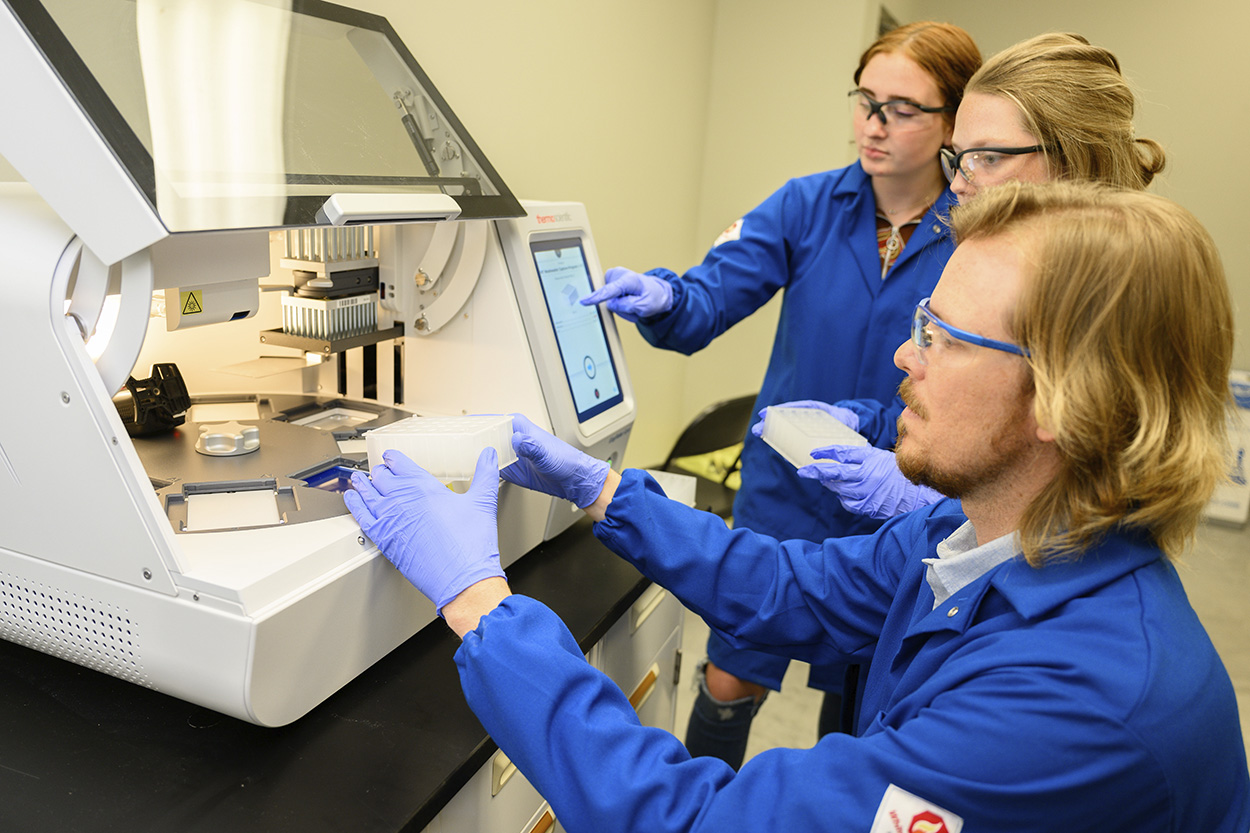 Picture of professor and students operating equipment