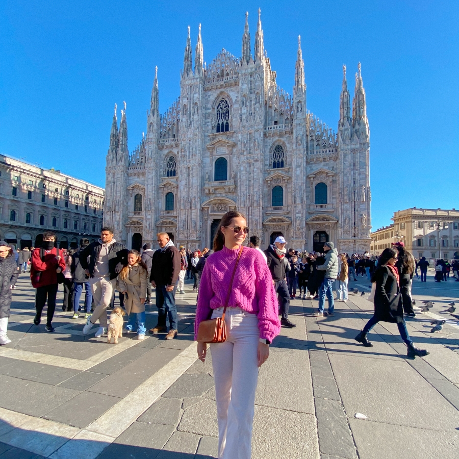 student stands in front of a beautiful building