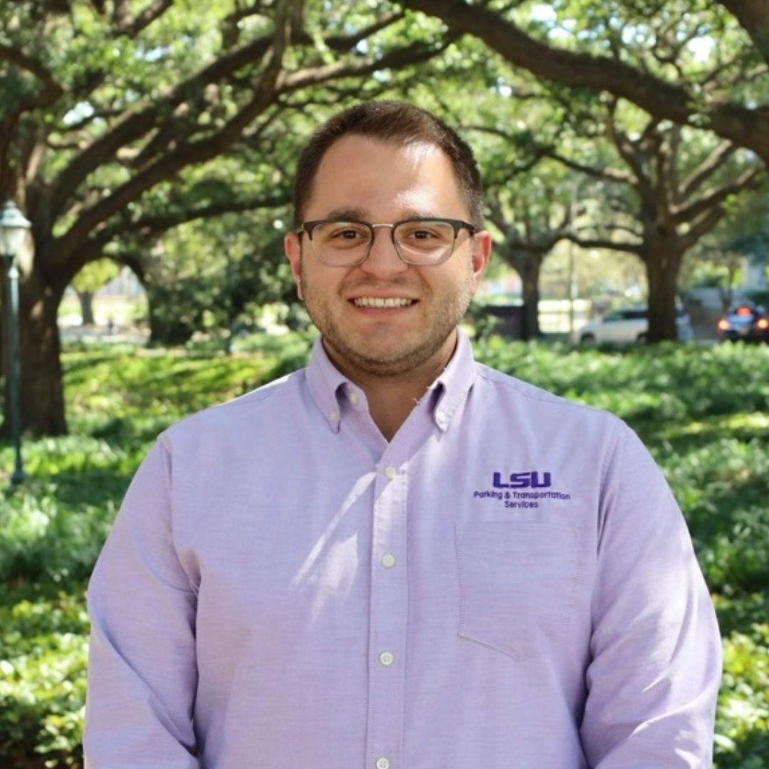 man smiling in purple polo